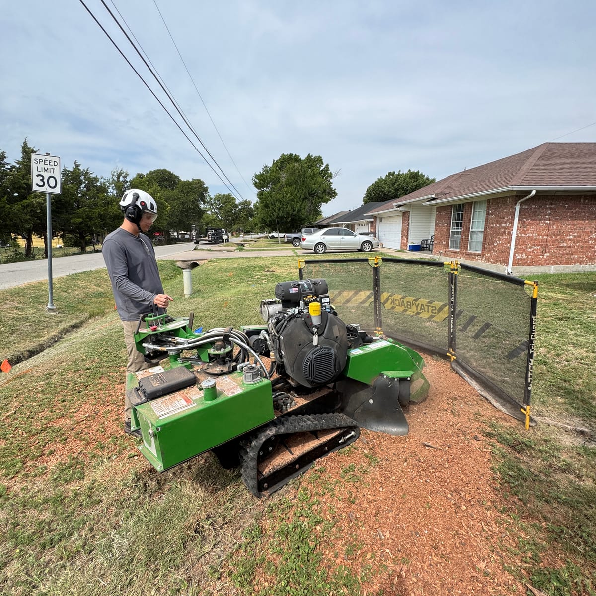 A Grind Texas operator running the 2021 Bandit SG40 stump grinder behind debris screens on a Princeton, TX job